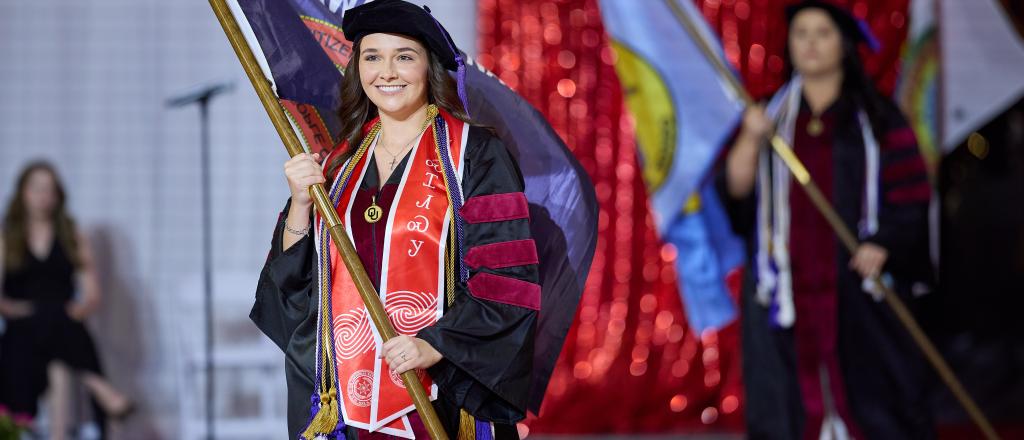 Students processing at commencement with tribal nation flags